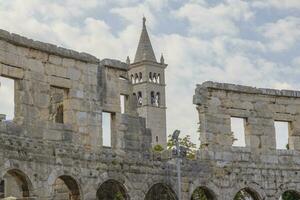 View to a church from inside the Roman amphitheater in the Croatian city of Pula photo