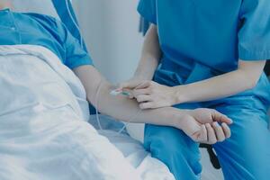 Injured patient showing doctor broken wrist and arm with bandage in hospital office or emergency room. Sprain, stress fracture or repetitive strain injury in hand. Nurse helping customer. First aid. photo