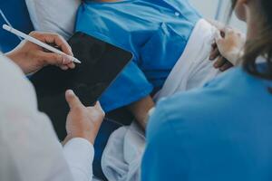 Injured patient showing doctor broken wrist and arm with bandage in hospital office or emergency room. Sprain, stress fracture or repetitive strain injury in hand. Nurse helping customer. First aid. photo