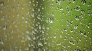 gotas de lluvia corredizo y que cae en el vaso de un ventana un lloviendo día video