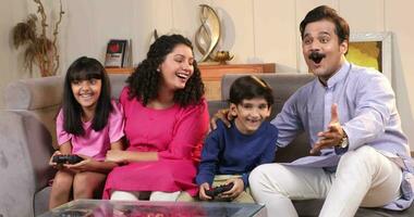 azione video di contento famiglia giocando video Giochi a casa e avendo divertimento insieme