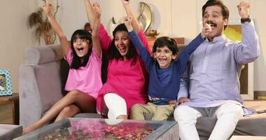 Family Sitting At Home Together Watching Cricket Match On Tv video