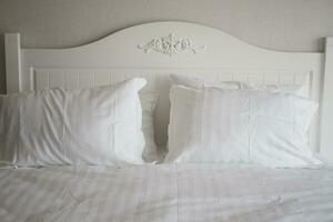almohada blanca alineada en la cama foto