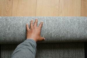 top view of men rolling out new rug. photo