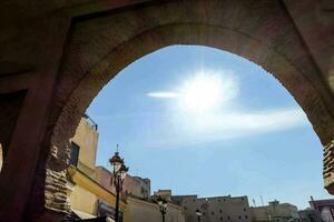 the sun shines through an archway in an old city photo