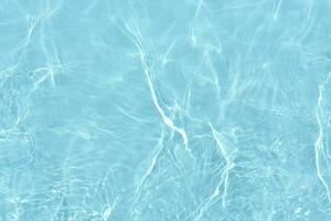 Defocus blurred transparent blue colored clear calm water surface texture with splashes reflection. Trendy abstract nature background. Water waves in sunlight with copy space. Blue watercolor shine. photo