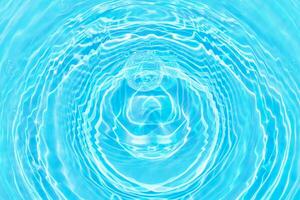 Defocus blurred transparent blue colored clear calm water surface texture with splashes reflection. Trendy abstract nature background. Water waves in sunlight with copy space. Blue watercolor shine. photo