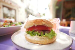 hamburguesa con queso con ensalada y tomate en al aire libre café foto