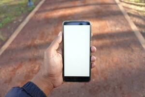 rear view of young man using smart phone at outdoor photo