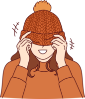 Woman covers face with knitted hat with pompom and smiles standing in warm sweater png