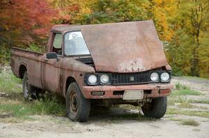 antiguo oxidado coche en el bosque foto