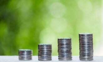 Business Finance and Money concept, Money coin stack growing graph with green tree bokeh background,investment concept photo