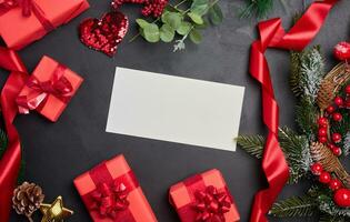 White envelope and Christmas wreath on a black background, top view photo