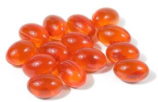 Orange capsules with fish oil on a white background photo