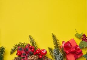 Christmas decor, gifts wrapped in red paper on a yellow background, top view. photo