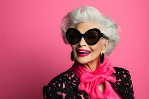 Fashionable elderly woman isolated on pink photo