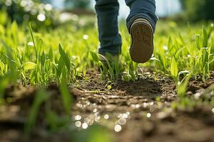 Children's feet in boots walk on green grass with in a field. Generated by artificial intelligence photo