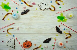 Terrible sweets are laid out on a wooden table to celebrate Halloween photo