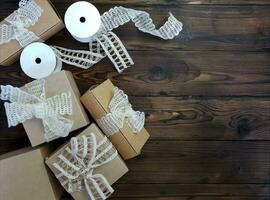 On a wooden table there are craft boxes decorated with bows. photo