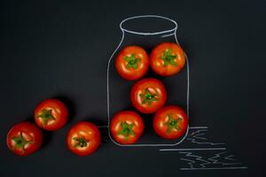 creativo foto de tomate envase. un banco es dibujado con tiza en un negro antecedentes.