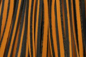 Closeup Black And Orange Pappardelle Italian Pasta, Fresh Wheat Product, Background And Texture. Top View. Egg Dry Ribbon Noodles, Long Rolled Macaroni or Uncooked Spaghetti. Horizontal Macro Flatly photo