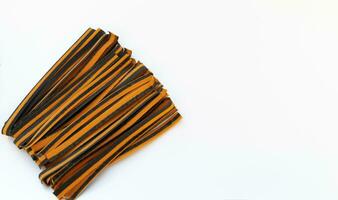 Black And Orange Pappardelle Italian Pasta, Fresh Wheat Product on White Background. Top View, Space For Text. Egg Dry Ribbon Noodles, Long Rolled Macaroni or Uncooked Spaghetti Isolated. Horizontal photo