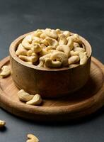 Cashews in a wooden bowl on the table photo