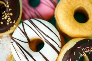 donuts Colorful variety and Variety of flavors mix of multi colored sweet donuts with frosted sprinkled on blue background. top view photo