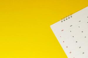 close up top view calendar 2020 month december end of the year schedule to make appointment meeting or manage timetable each day lay on yellow background for planning work and travel concept. photo