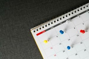 mark the event day with a pin. Thumbtack in calendar concept for busy timeline organize schedule,appointment meeting reminder. planning business meeting or travel holiday planning concept. soft focus photo