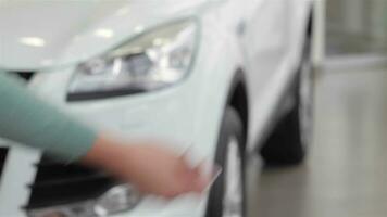 Saleswoman giving car key in a motor show video