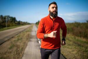 Adult man is jogging outdoor on sunny day. photo
