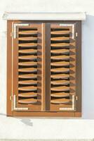Picture of an old window with closed brown shutters photo
