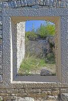 View through a window opening in an antique natural stone wall photo