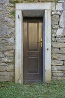 Image of a brown entrance door to a residential building with an antique facade photo