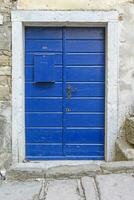 Image of a blue entrance door to a residential building with an antique facade photo