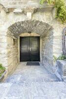 Image of a red entrance door to a residential building with an antique facade photo