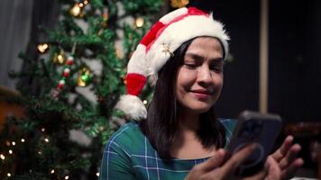 contento mujer a hogar conectando con su teléfono inteligente en Navidad día video