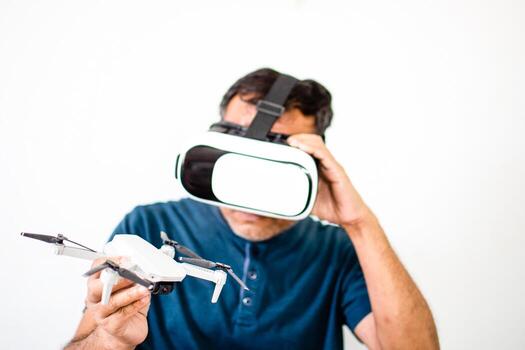An alone man holds a drone and plays VR to operate the drone. The young man was happy while watching a tutorial on how to flying with VR. Virtual reality wearing a male head. Copy space for design. photo