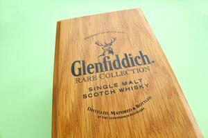 Close-up of rare collection wooden box Glenfiddich single malt scotch whisky on green background. Popular luxury alcoholic drink of Scotland. Moscow, Russia - September 8, 2022 photo