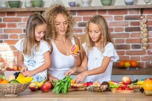 madre y hijas Cocinando juntos en el cocina. sano comida concepto. retrato de contento familia con Fresco batidos contento hermanas foto