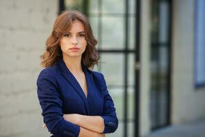 retrato de un exitoso negocio mujer en frente de moderno negocio edificio. joven gerente poses afuera. mujer empleado de un oficina. foto