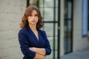 retrato de un exitoso negocio mujer en frente de moderno negocio edificio. joven gerente poses afuera. mujer empleado de un oficina. foto