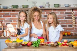 madre y hijas Cocinando juntos en el cocina. sano comida concepto. retrato de contento familia con Fresco batidos contento hermanas foto