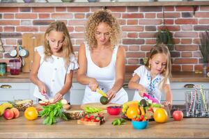 madre y hijas Cocinando juntos en el cocina. sano comida concepto. retrato de contento familia con Fresco batidos contento hermanas foto