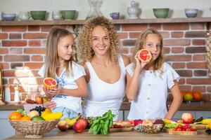 madre y hijas Cocinando juntos en el cocina. sano comida concepto. retrato de contento familia con Fresco batidos contento hermanas foto