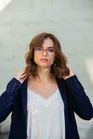 Portrait of a successful business woman in front of modern business building. Young manager poses outside. Woman employee of an office. photo