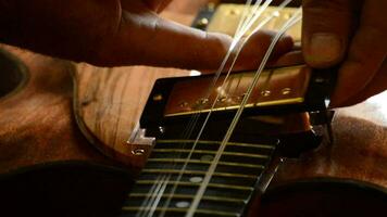 Luthier placing an electric guitar pickup in the workshop video