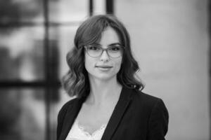 Portrait of a successful business woman in front of modern business building. Young manager poses outside. Woman employee of an office. photo