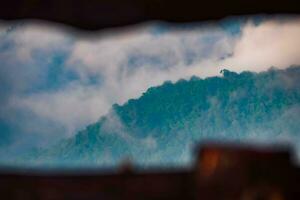 The stunning view from a tourist's standpoint as they go down a hill on a foggy trail with a hill and a background of a golden sky in Forest Park, Thailand. Bird's eye view. Aerial view. photo